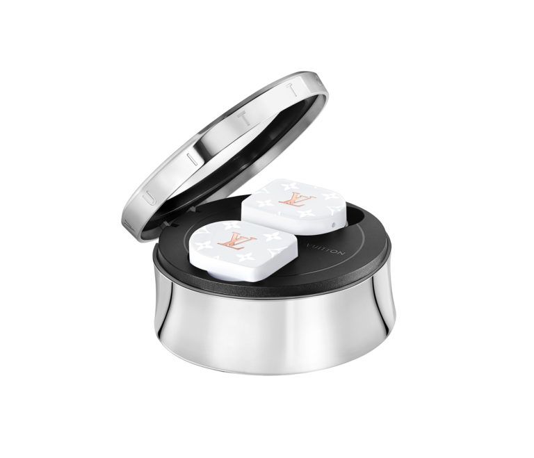 Louis Vuitton wireless earbuds in a silver charging case with the lid open, featuring the LV monogram design in white and gold.