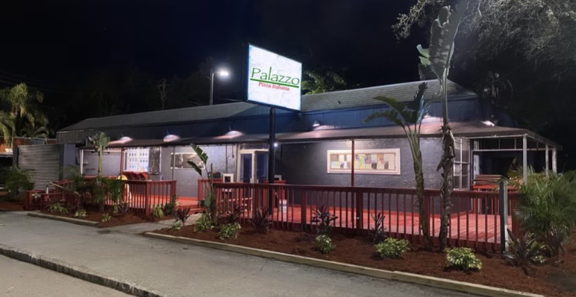 Exterior of Palazzo Pizza in Tampa at night with outdoor patio seating and illuminated signage.