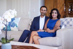 Shilen Patel's and his wife sitting on a couch smiling