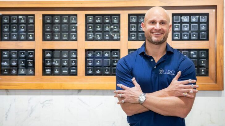 Brian Leclerc, executive leader at International Diamond Center, standing inside an IDC showroom with diamond engagement rings displayed behind him