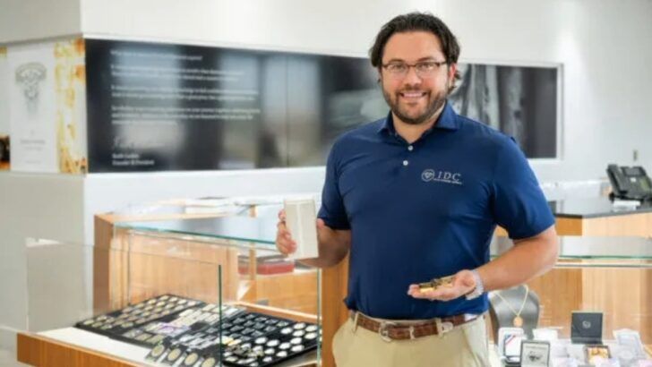 Chad Masters, executive at International Diamond Center, holding jewelry inside an IDC showroom