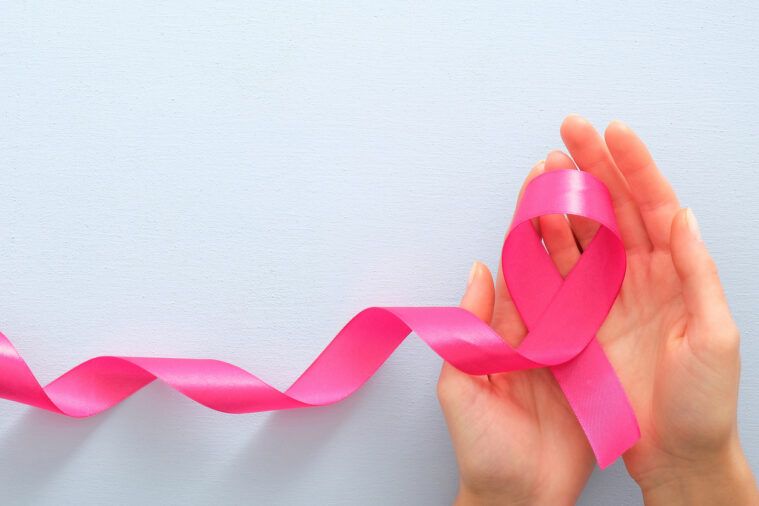Cropped Hands Of Woman Holding Breast Cancer Awareness Ribbon