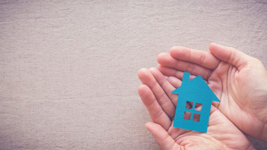 hands holding paper house, homeless shelter and real estate concept, house protecting, social distancing