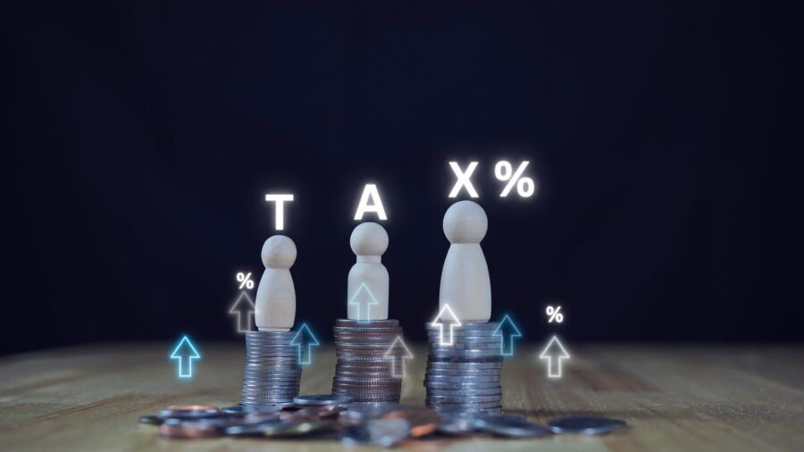 TAX icon on a stack of coins. Concept of taxes paid by individuals and companies, VAT, income tax, property tax, property tax, Background for your business.