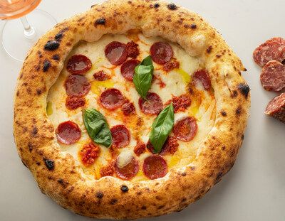 A Roman-style pepperoni pizza with basil leaves and crisp crust served at Piccolo Buco in Tampa.