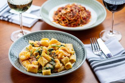 A bowl of mezzi rigatoni alla vodka and a plate of pasta with tomato sauce served with glasses of Cooper’s Hawk wine at Piccolo Buco in Tampa.