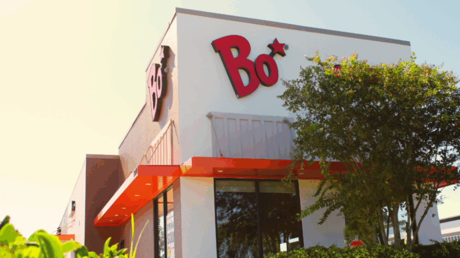 Exterior of a Bojangles restaurant in Pinellas Park, featuring the signature red “Bo” logo on a white building with an orange awning and tree in the foreground.