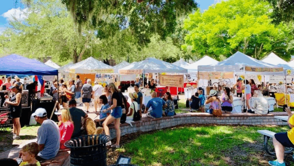 Visitors gather under the oaks at the Dunedin Downtown Market, one of Tampa Bay Markets’ most popular weekend destinations.