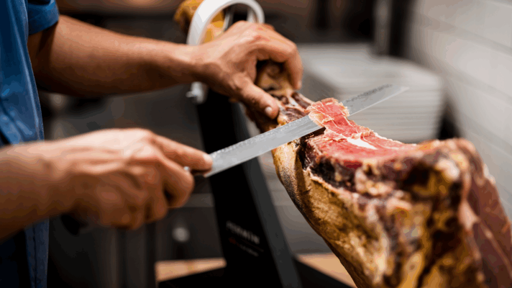 Chef slicing jamón ibérico ham at Ceviche Tapas Bar & Restaurant.