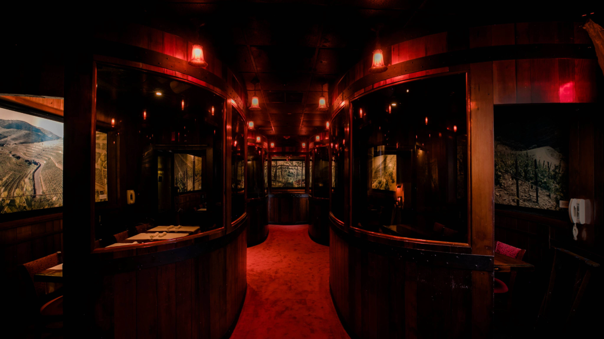 Interior view of the Harry Waugh Dessert Room at Bern’s Steak House, showing private redwood booths and soft red lighting.