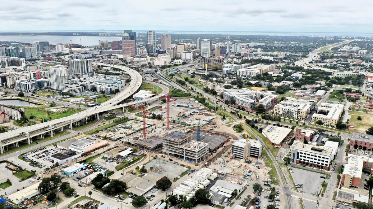 Aerial view of the Gasworx development under construction in Ybor City, with downtown Tampa’s skyline and the Selmon Expressway in the background.