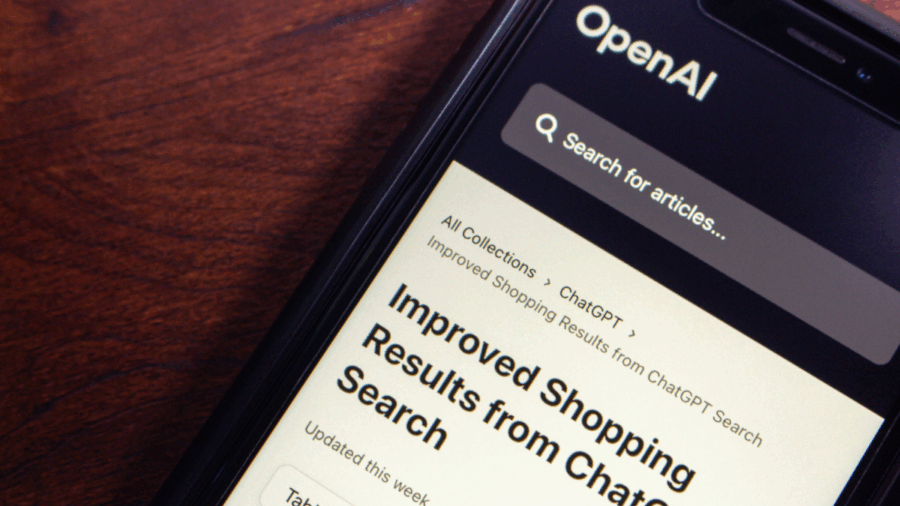 A smartphone screen displays OpenAI’s ChatGPT interface with an article titled “Improved Shopping Results from ChatGPT Search.”
