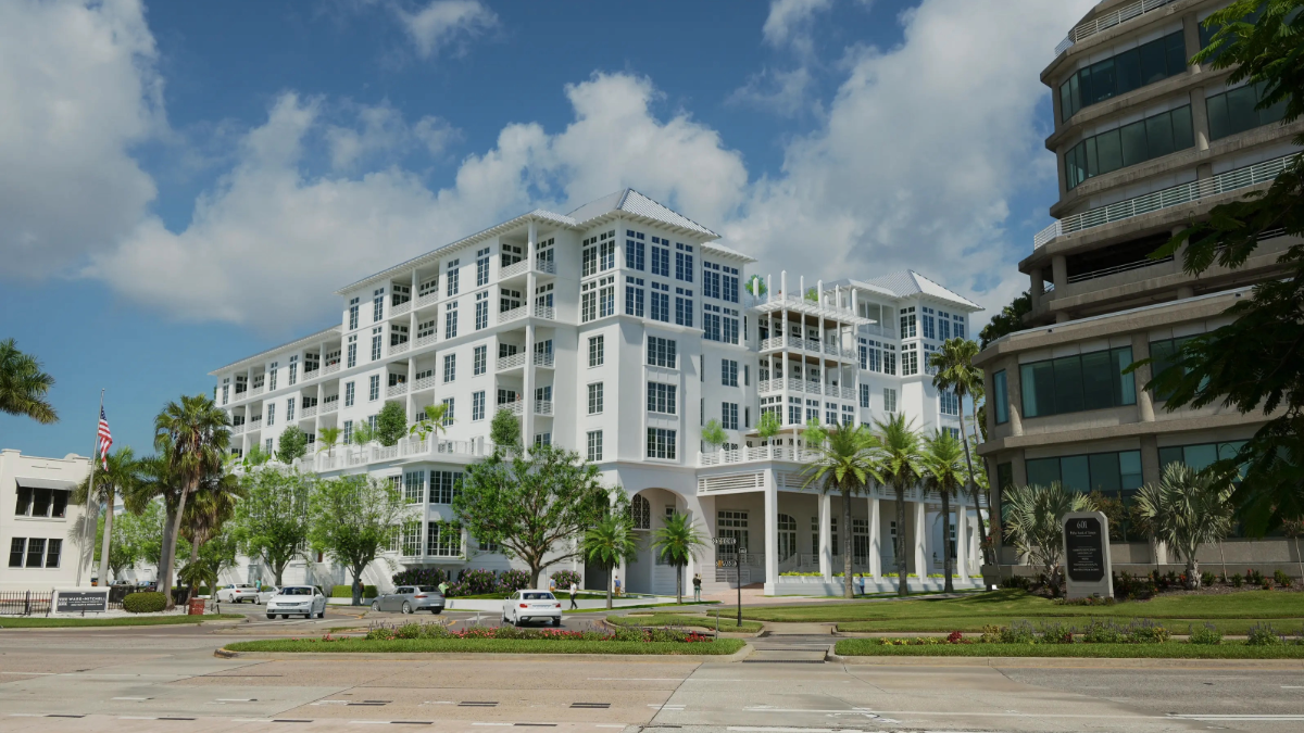 Wide shot of Magnolia Hotel & Residences from Bayshore Boulevard, showing its white façade, balconies and surrounding greenery.