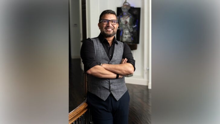 Dr. Ali smiling with arms crossed inside his home.