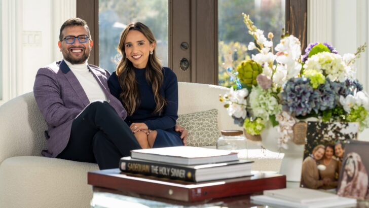 Dr. Ali sitting with his wife on a couch in their living room.