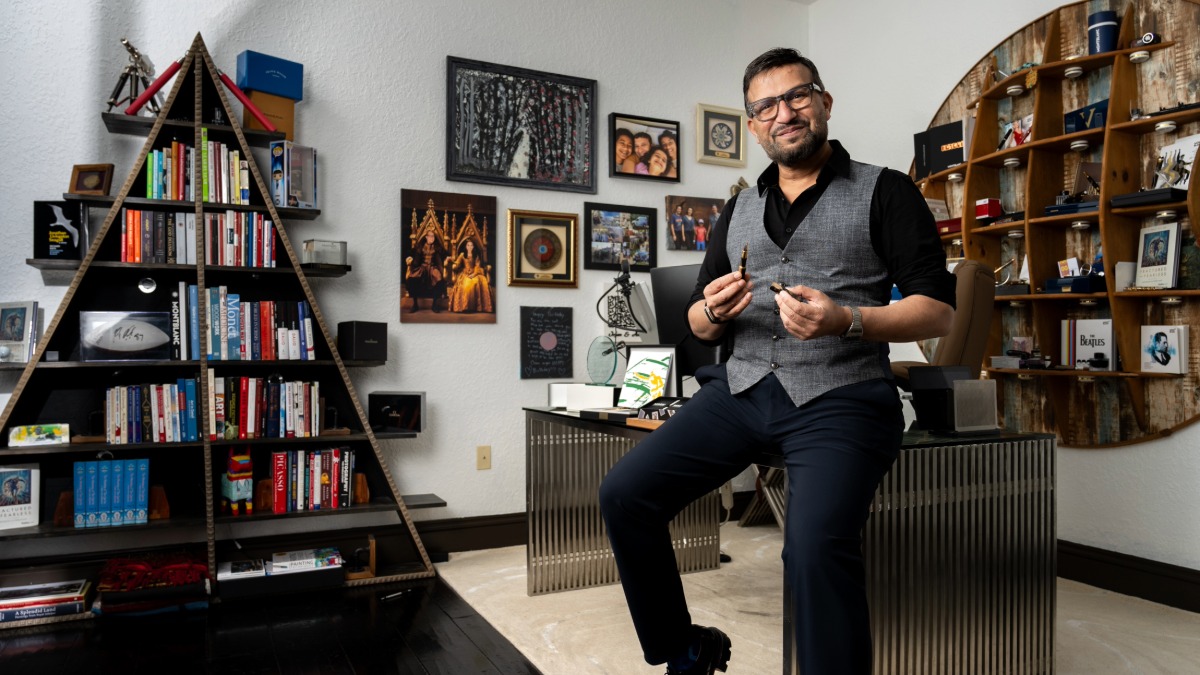 Dr. Ali sitting in his personal office surrounded by books and artwork.