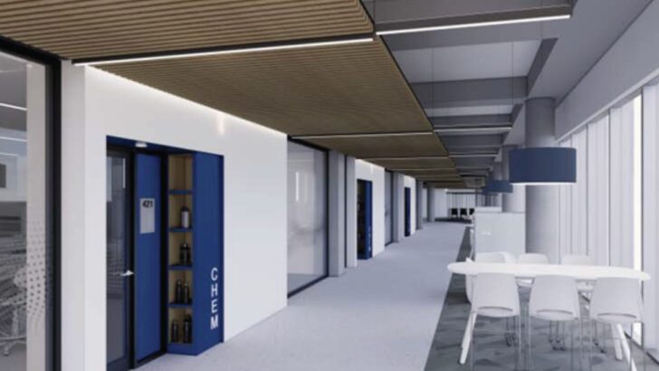 Lobby and seating area inside UTampa’s new science building with wood details and a digital screen.