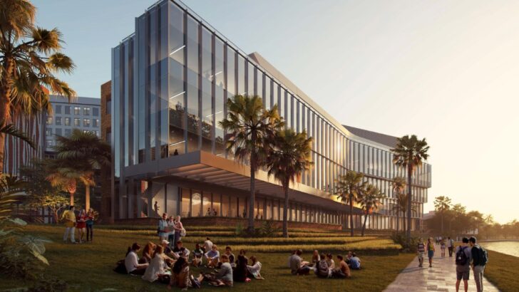 Exterior view of UTampa’s new science building facing the river with glass walls and red brick.