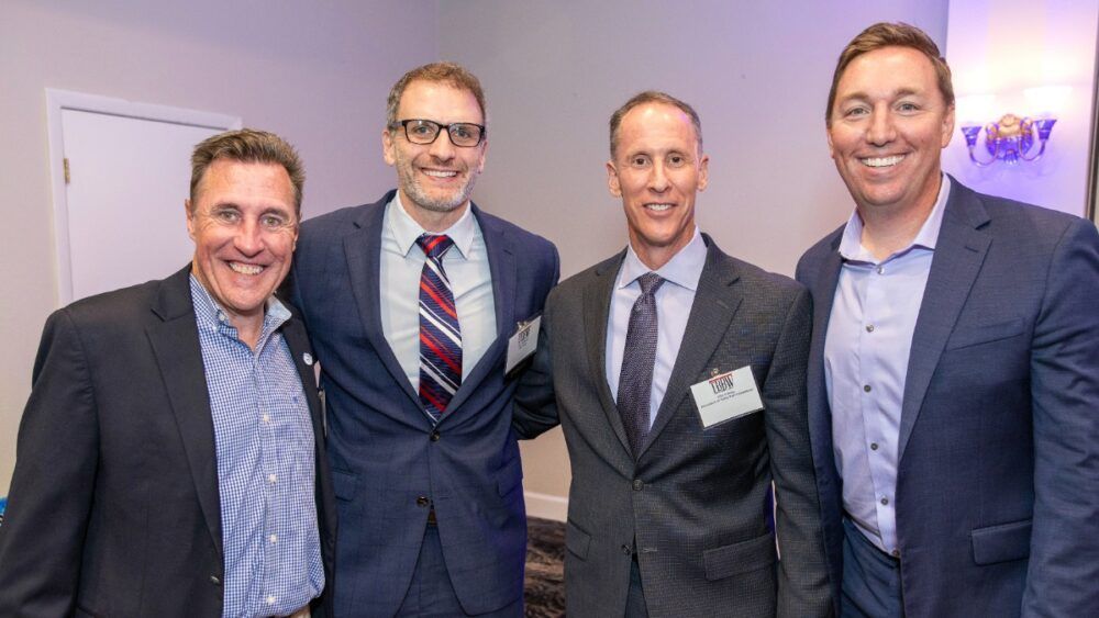Two guests pose in front of the TBBW step-and-repeat banner