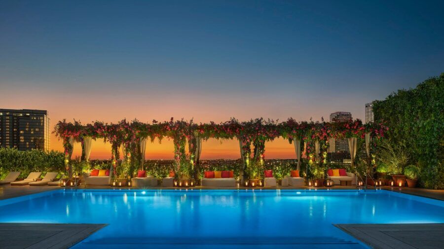 Rooftop pool at The Tampa Edition at sunset, overlooking Water Street with floral cabanas and city views