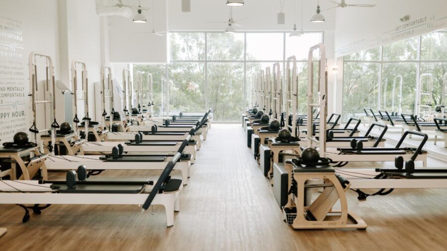 BODYBAR Pilates reformer machines lined up in a bright, modern studio space