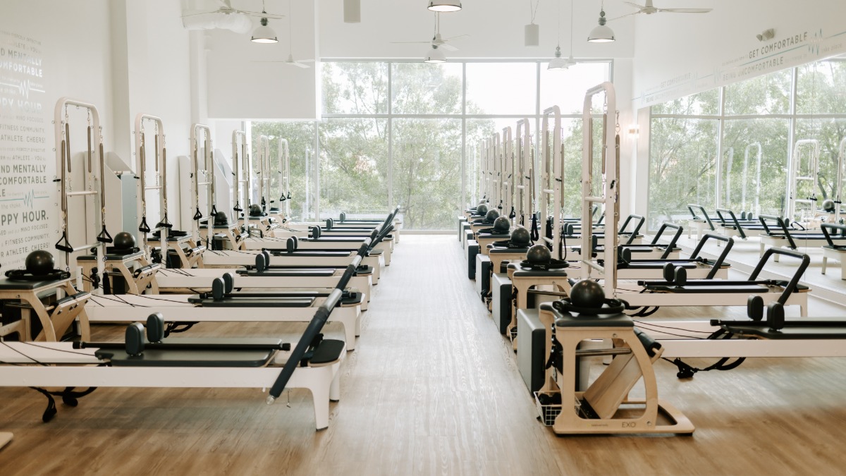 BODYBAR Pilates reformer machines lined up in a bright, modern studio space