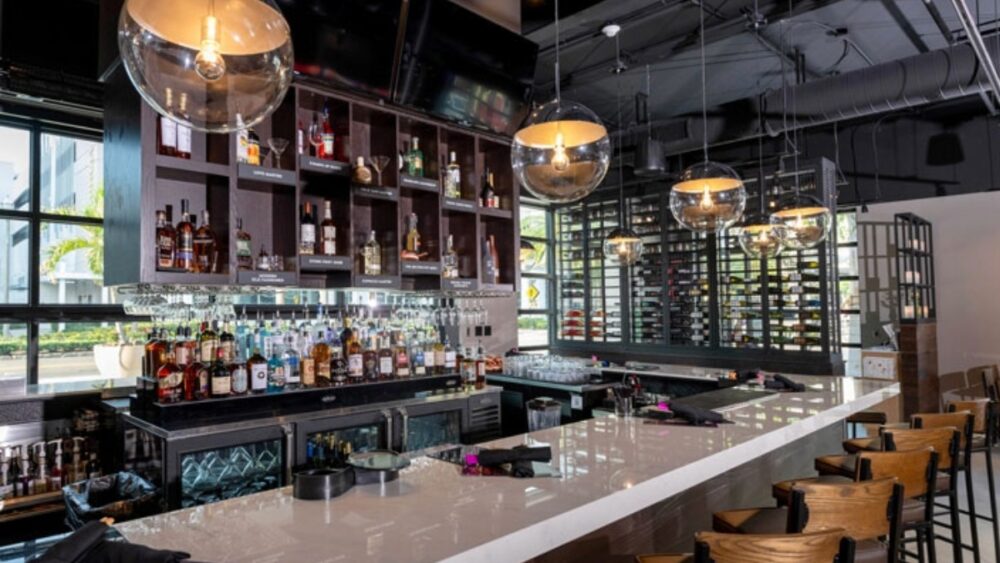 Interior view of the Melting Pot bar in St Petersburg featuring a marble bar top and backlit shelving
