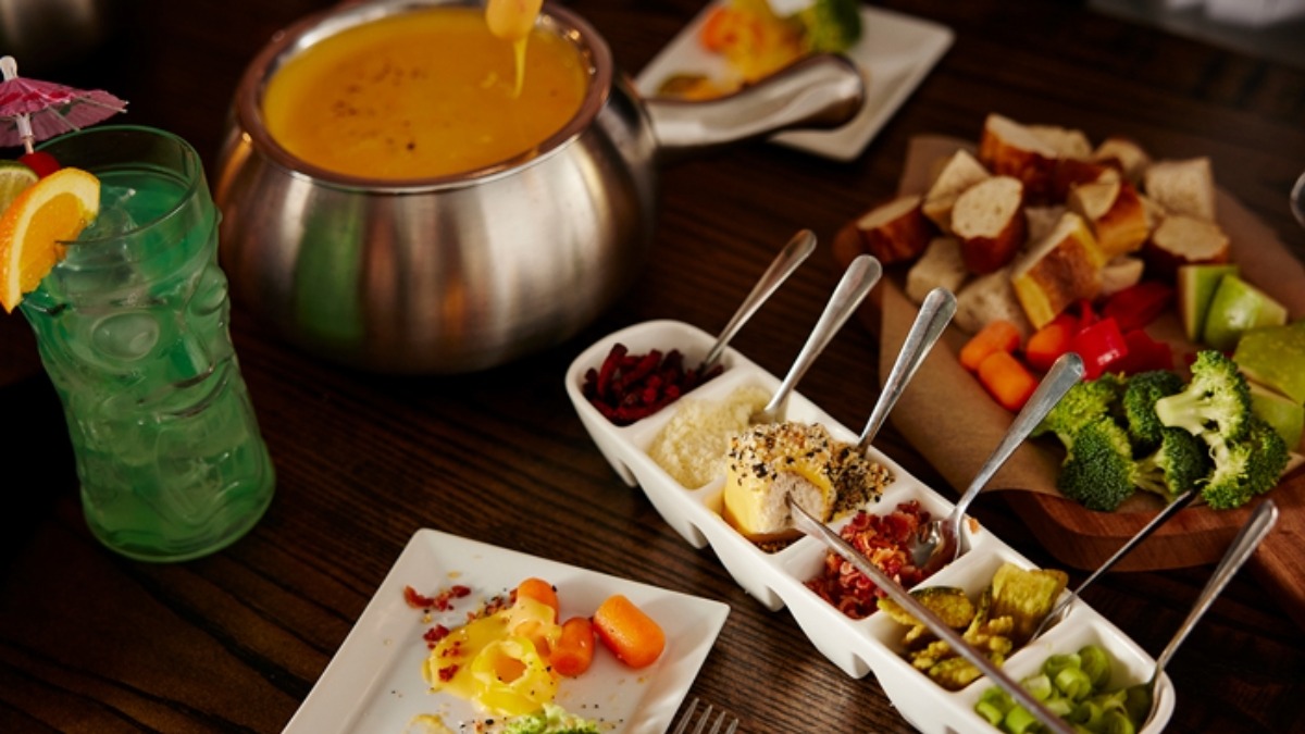 Cheese fondue and a spread of fresh vegetables and dipping items at Melting Pot