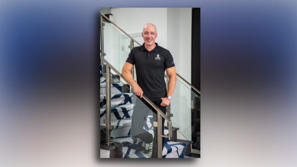 Trevor Burgess standing on a staircase during his TBBW cover interview shoot.