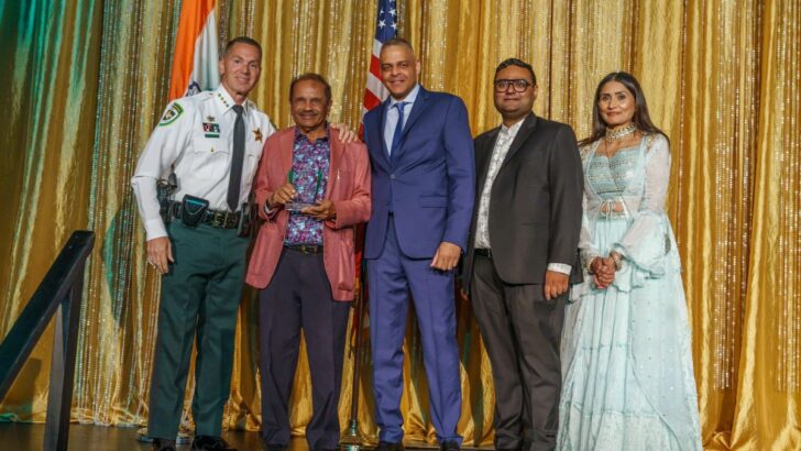 Sheriff Chad Chronister stands with Council President Ketan Patel and Vice Chair Ami Patel during an award presentation.
