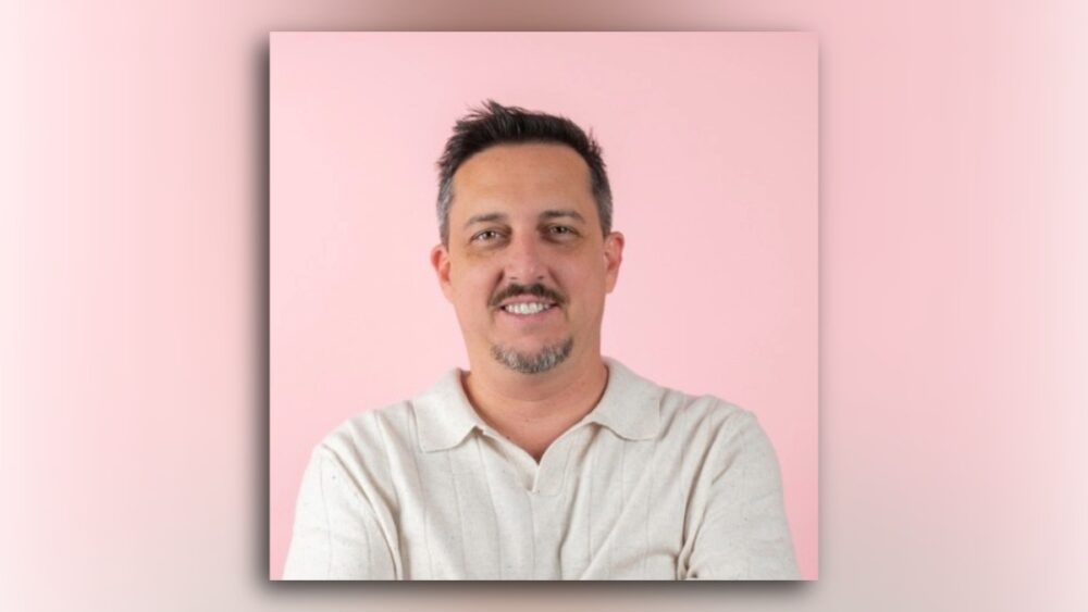 Primo Amicucci, VP of Culinary at Fresh Kitchen, photographed against a pink background.