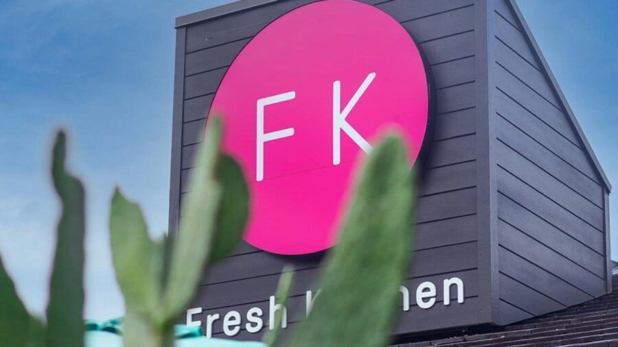 Fresh Kitchen restaurant exterior with FK logo sign behind cactus plants