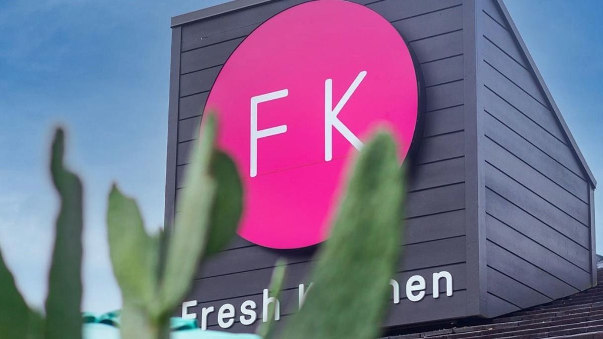 Fresh Kitchen restaurant exterior with FK logo sign behind cactus plants