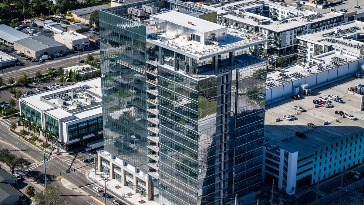Aerial view of a high-rise office tower in Midtown Tampa surrounded by new development.