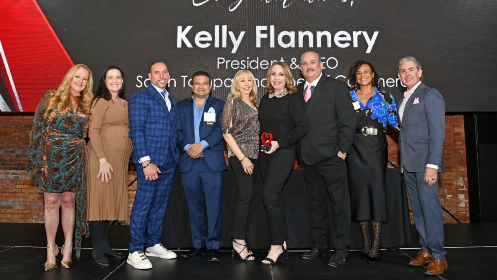 Group photo of Kelly Flannery being honored on stage as the Judges Choice Award recipient at the 2025 TBBW Philanthropists of the Year Awards.