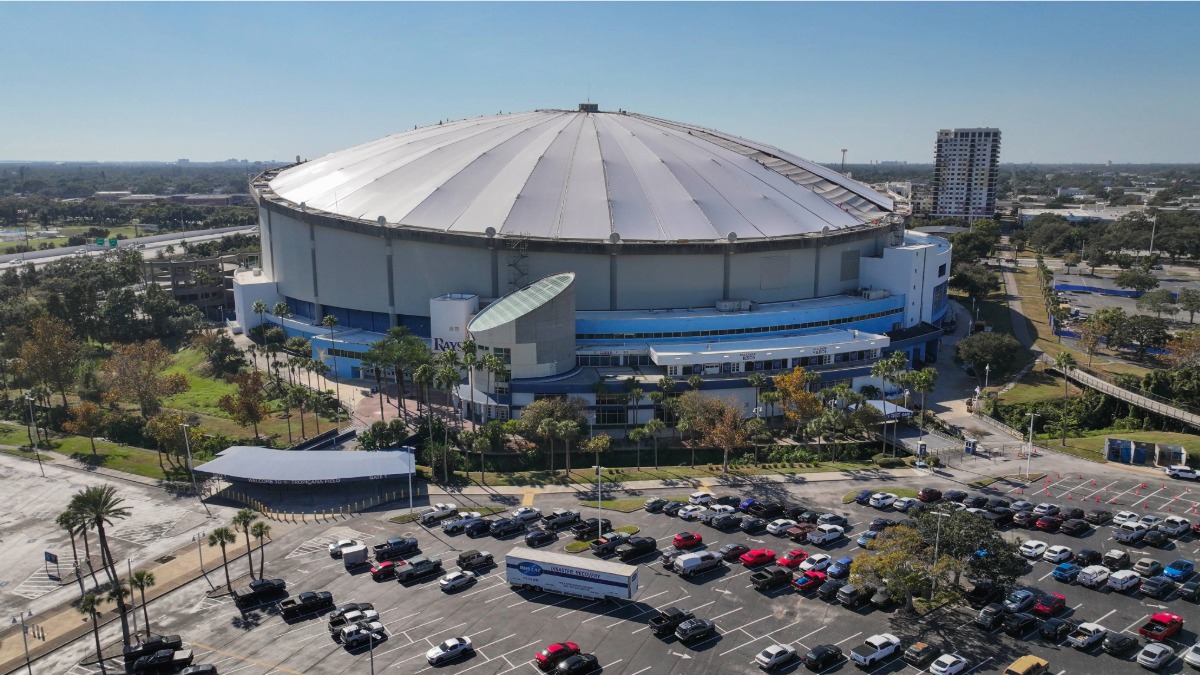 Aerial image of Tropicana Field under bright blue skies with St. Petersburg neighborhoods in the background.