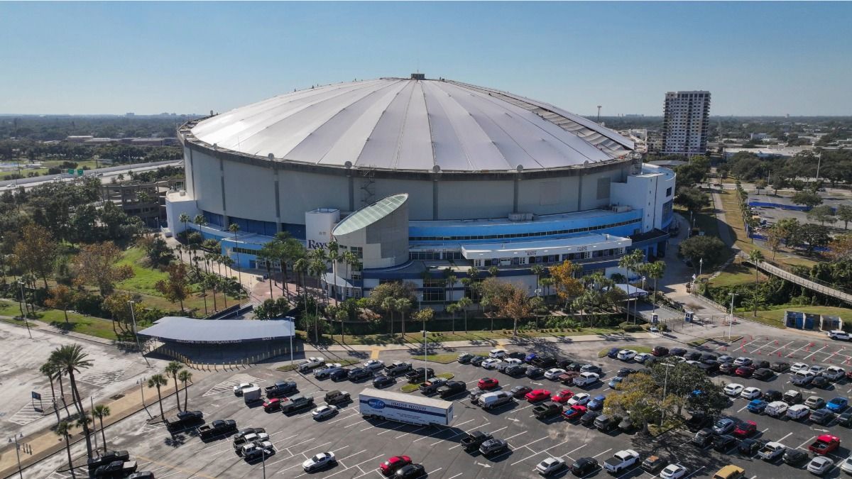 Aerial image of Tropicana Field under bright blue skies with St. Petersburg neighborhoods in the background.