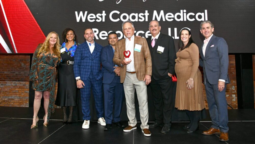 Group photo of West Coast Medical Resources LLC on stage at the 2025 TBBW Philanthropists of the Year Awards holding their Corporate and Business Category award.