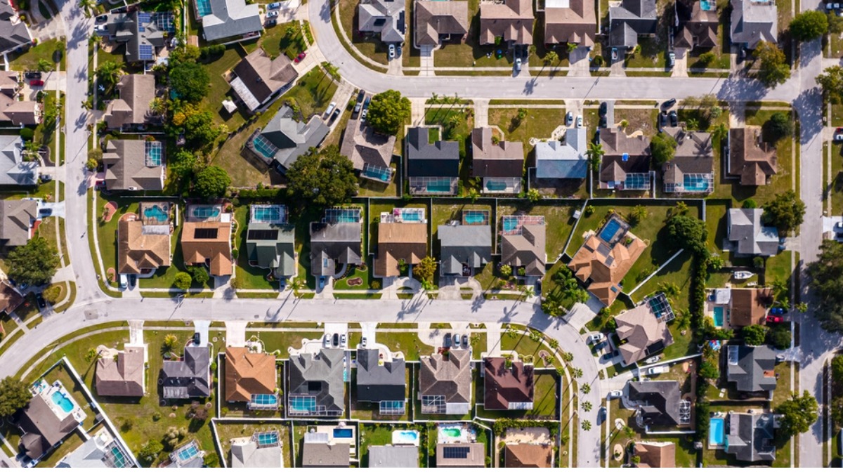 Aerial view of a suburban neighborhood in Tampa Bay showing single family homes, streets and backyard pools.