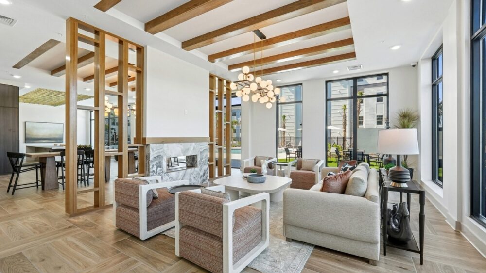 Lobby lounge at The Whitt in Riverview with wood beams, soft seating and large windows overlooking the pool area.