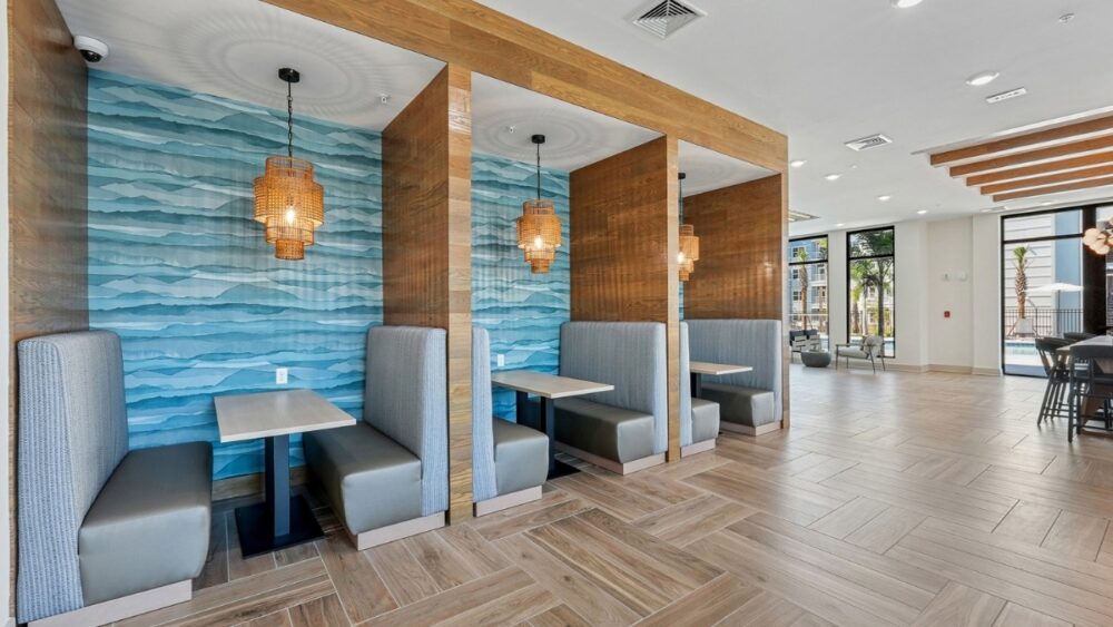 Lobby lounge at The Whitt in Riverview with wood beams, soft seating and large windows overlooking the pool area.