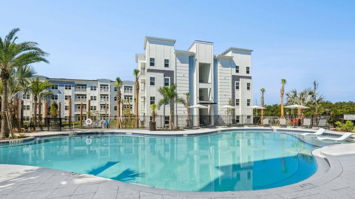 Outdoor resort style pool at The Whitt in Riverview with lounge chairs and surrounding apartment buildings.
