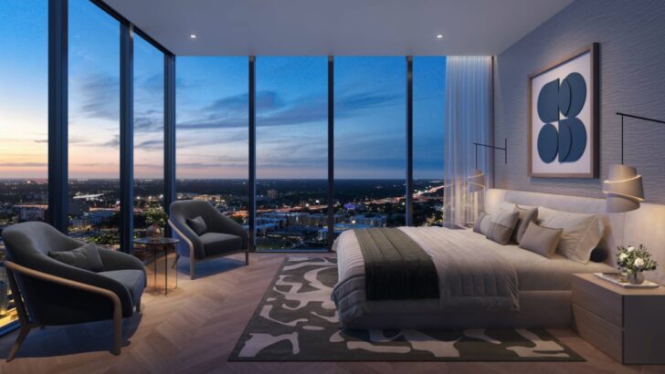 Rendering of a Hotel ORA master bedroom with large windows and a city view at sunset
