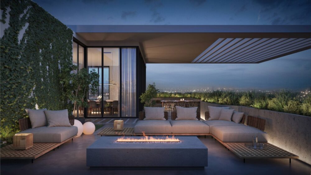 Rooftop lounge at Gallery Haus with a long fire pit, modern seating and views of St. Pete at dusk.