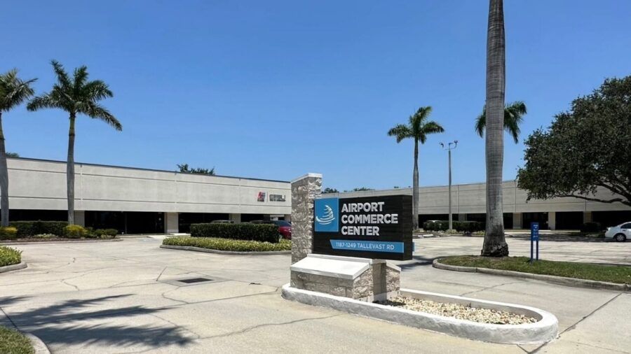 A view of Airport Commerce Center in Sarasota showing its single story industrial buildings, palm trees and the property’s main entrance sign on Tallevast Road.