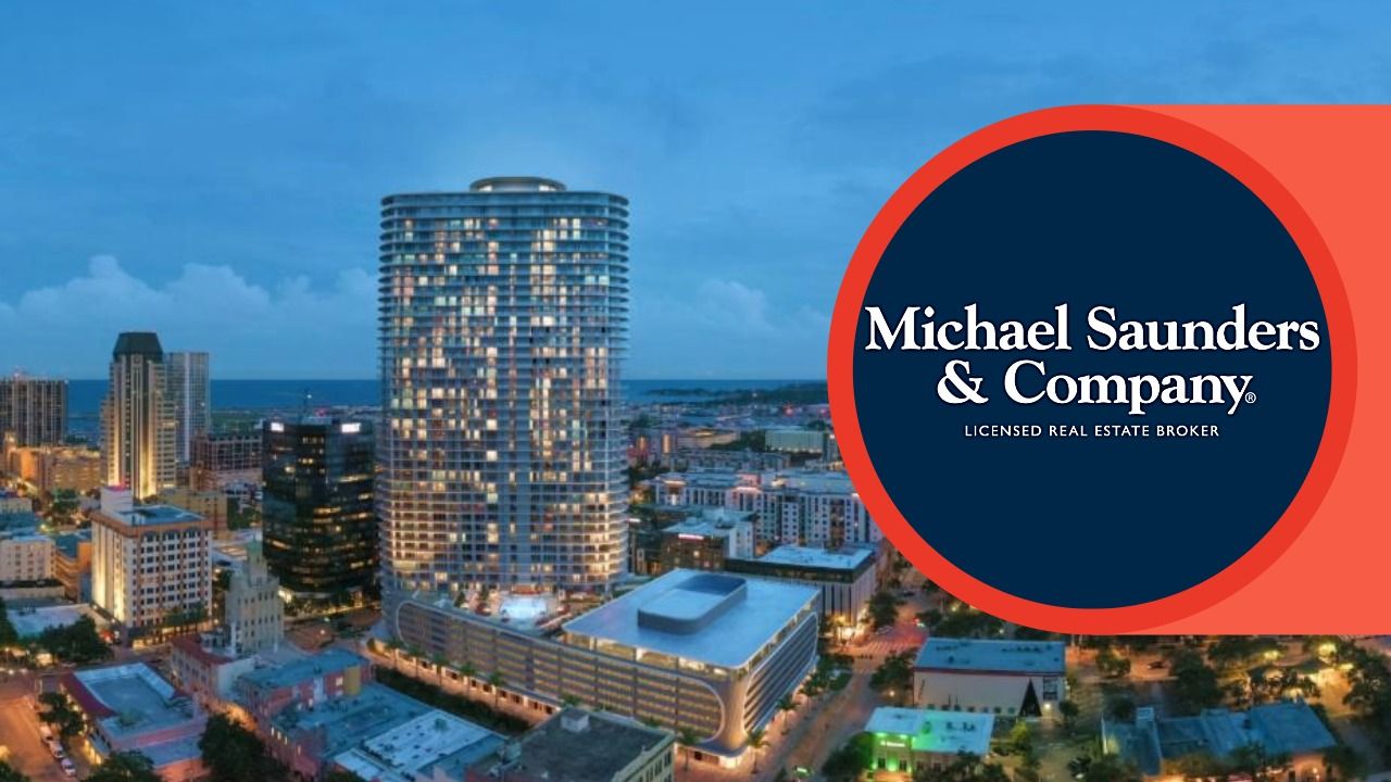 A twilight aerial view of downtown St. Petersburg with the 46-story Residences at 400 Central tower illuminated; Michael Saunders & Company logo displayed on the right.