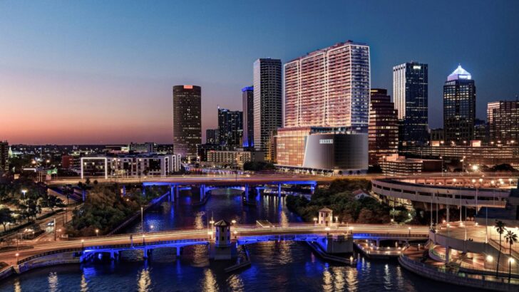 A night view of Pendry Tampa with downtown lights and the Riverwalk