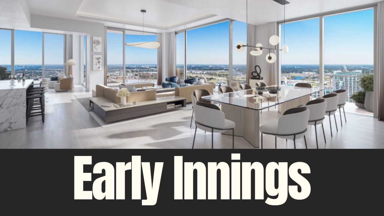 Interior rendering of a luxury condominium at ONE Tampa, showing an open living and dining space with floor-to-ceiling windows overlooking downtown Tampa.