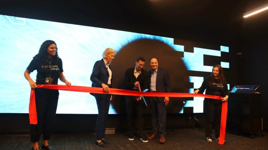 Leaders and team members cut a ribbon during the launch of The Digital Suite Tampa at Embarc Collective.