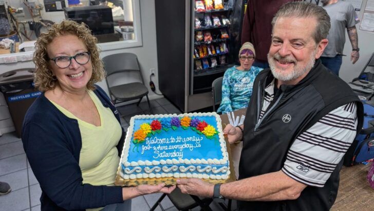 Dave and Tara Schwanke hold a cake marking their final day at Precise Technologies as employees celebrate the founders’ retirement after more than 30 years.